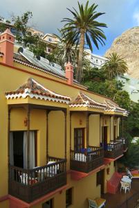 巴耶格兰雷伊贝壳花园酒店的带阳台的黄色房子和棕榈树