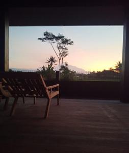 NgaglikBaku living villa的靠窗边的长凳,享有日落美景