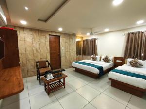 艾哈迈达巴德Hotel Kinara的酒店客房设有两张床和一张桌子。