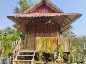 马德望Odambang Village Homestay的一座带红色屋顶的小型木制建筑