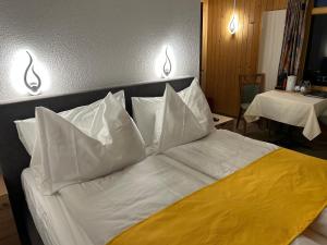 茨韦西门Post Hotel Vista的一张带白色床单和枕头的床