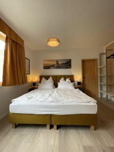 门兴格拉德巴赫Appartement mitten in der Stadt的卧室配有一张带白色床单和枕头的大床。