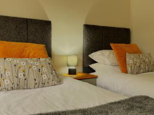 海伦斯堡The Gate Lodge的一间卧室配有两张床和床头灯。