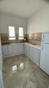 托泽尔Dar elrayen的一间大厨房,配有白色的橱柜和一台冰箱