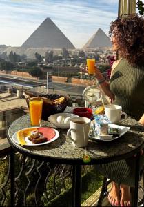 开罗Unique Pyramids View INN的坐在桌子上吃喝的女人