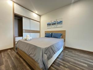 胡志明市Qhome的一间卧室配有一张带蓝色枕头的大床