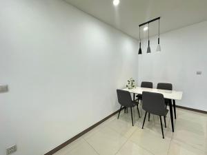 胡志明市Qhome的白色的用餐室配有桌椅