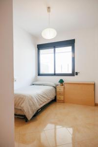 卡耐特蒂贝兰格Lujoso apartamento de dos habitaciones en la playa de Canet的一间卧室设有一张床和一个窗口