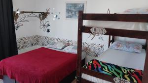 纳韦甘蒂斯FrenteMar OuroVerde BetoCarrero的一间卧室设有两张双层床和红色毯子