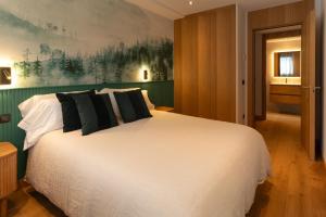 埃尔塔特Tarter Mountain & SPA的卧室配有一张带黑色枕头的大型白色床。