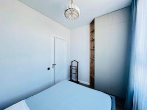 阿斯塔纳Кок Жайлау apartament的一间卧室配有一张床和一个吊灯