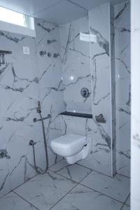 蒂鲁帕蒂Hotel Lorven的白色的浴室设有卫生间和淋浴。