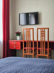 里加Muzeja apartamenti的一间卧室配有两把椅子和一张书桌及电视