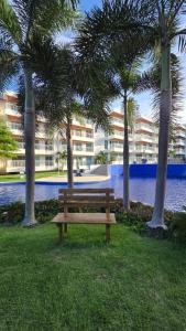 阿奎拉兹Apartamento Confortável - Porto das Dunas - Perto do Beach Park的棕榈树公园的木凳