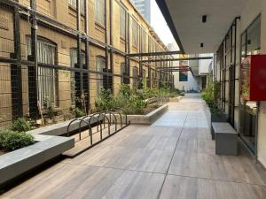 圣地亚哥Departamento ñuñoa的一座有长椅和植物的建筑的空走廊