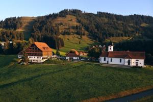 HeiligkreuzHotel Kurhaus Heiligkreuz的绿色山丘上的小村庄,有教堂