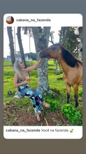 圣弗朗西斯科-迪保拉Cabana na Fazenda的坐在马旁边坐在地上的女人