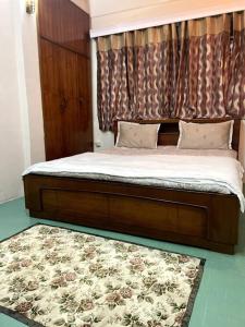 甘托克The First House - 2 BHK in Main Gangtok的卧室内的一张木架床和地毯