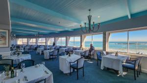 开普敦The Blue Peter Hotel的一间配备有白色桌椅的海景餐厅