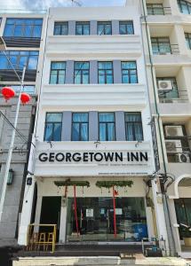 乔治市Georgetown Inn by Sky Hive的一座白色的建筑,上面标有棕色旅馆