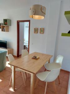 伊斯兰蒂拉Apartamento en Islantilla Golf的一间带木桌和白色椅子的用餐室
