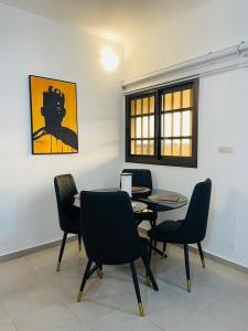 BéWendyla Luxury's的用餐室配有桌椅和绘画作品