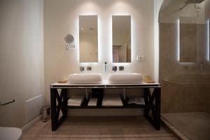 卡斯泰拉马莱Costamante Suites & Spa的一间带两个盥洗盆和淋浴的浴室