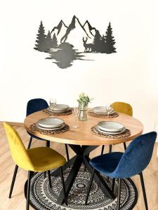 洛伊克巴德Studio magnifique avec terrasse spacieuse Loèche-les-Bains Vacances的餐桌和桌椅,墙上挂着山 ⁇ 