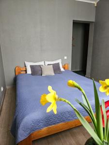 里加Muzeja apartamenti的一间卧室,床上有黄色的鲜花