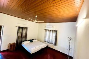 阿勒皮Marari Oceanscape的一间卧室设有一张床和木制天花板
