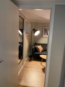 奥勒松Apartment close to Aalesund center的走廊通往带沙发的客厅