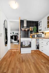 奥勒松Apartment close to Aalesund center的厨房配有白色橱柜和硬木地板。