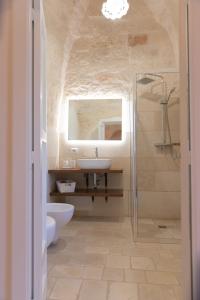 奇斯泰尼诺Masseria Carperi in the heart of Valle d'Itria的一间带水槽、卫生间和镜子的浴室