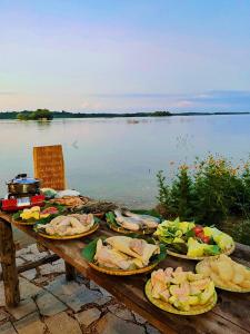 The Secret Garden Camping - Hồ Trị An的湖畔木桌,上面放着盘子