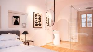 多瑙河畔克雷姆斯Smile Apartments im Stadtzentrum的一间卧室设有一张床和一个玻璃淋浴间