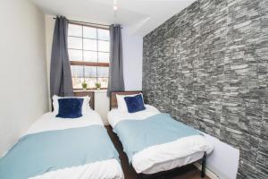 罗奇代尔3 bed apartment, centre of Rochdale的砖墙客房的两张床