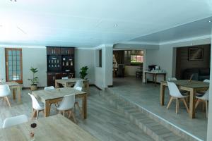 克莱克斯多普Tristan's Place Guest House的用餐室配有木桌和白色椅子