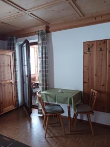 内维尔格拉滕Haus Mesner的一间带绿色桌椅的用餐室