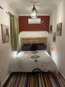 马拉喀什里亚德N10旅馆的一间卧室配有一张床和一个吊灯