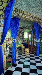 马哈赞加Châteaux Yolande的一间设有蓝色窗帘和 ⁇ 格地板的客房