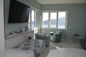 韦内雷港CaseMaggi Attico sul Mare, Penthouse on the Sea的一间卧室配有一张床、两把椅子和一台平面电视
