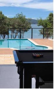 圣若昂-达巴拉Casa de temporada no Lago de Furnas-acesso a represa的享有游泳池的景色,配有桌子和桌子