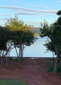 圣若昂-达巴拉Casa de temporada no Lago de Furnas-acesso a represa的一群树木在水体前