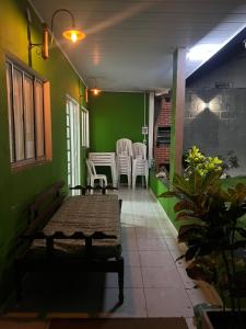 塞拉Casa do vovô caixa的门廊配有椅子和桌子,拥有绿色的墙壁