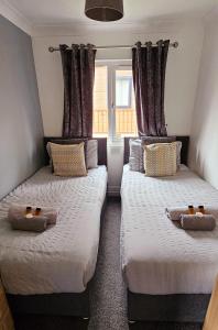 SwarlandTranquil Lodge hot tub and free golf的带2扇窗户的客房内的2张床