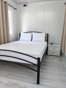 托罗尼Camping Anamour的卧室内的一张带白色床单和枕头的床