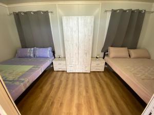 托罗尼Camping Anamour的铺有木地板的客房内的两张床