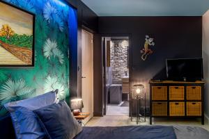 隆瑞莫Sunset Appart-Hotel 3 chambres, 2 Salles de Bain, proche Paris, Massy & Orly的一间卧室配有一张床,墙上拥有蓝色的灯光