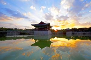庆州Gyeongju Bee House的日落时分池塘中央的一座中国建筑