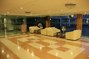 That Phanom那帕侬河景酒店的大堂设有白色的沙发和 ⁇ 格地板